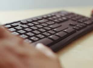 Man hands typing on a computer keyboard